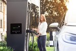 Eine Frau hält Ladestecker an einer Schnellladesäule der EnBW ODR AG in der Hand