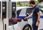 Mann hält Ladestecker an Elektroauto zum Starten des Ladevorgangs